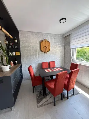 a dining room with a table and red chairs at Apartman ViR in Soko Banja