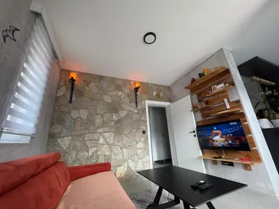 a living room with a couch and a stone wall at Apartman ViR in Soko Banja
