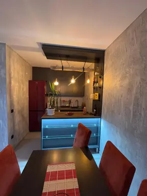 a kitchen with a table and some red chairs at Apartman ViR in Soko Banja