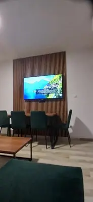 a living room with a flat screen tv on a wall at Vila Bela in Soko Banja
