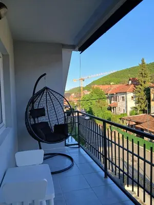 a balcony with a swing and a chair at Vila Bela in Soko Banja