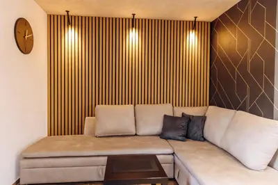 a couch in a room with a clock on the wall at Apartman Pavlović Lux in Soko Banja