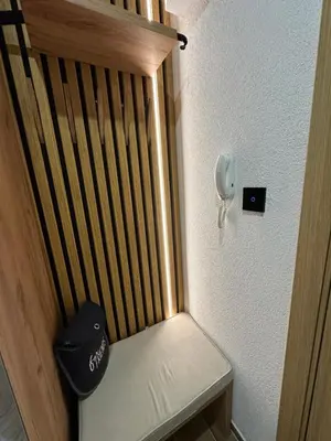 a bench in a room with a phone on the wall at Apartman Pavlović Lux in Soko Banja