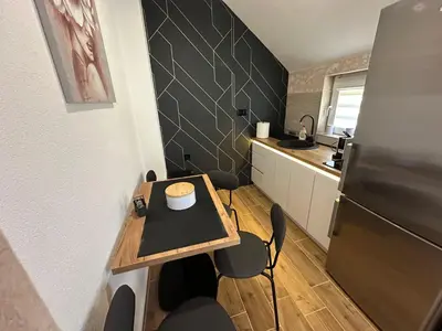 a small kitchen with a table and a refrigerator at Apartman Pavlović Lux in Soko Banja