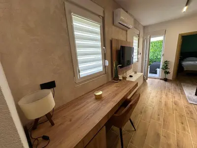 a room with a desk with a tv and a window at Apartman Pavlović Lux in Soko Banja