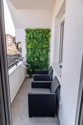 a room with chairs and a green wall at Apartman Pavlović Lux in Soko Banja