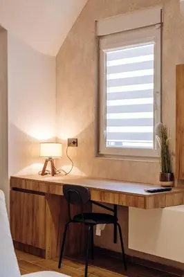 a desk with a lamp and a chair next to a window at Apartman Pavlović Lux in Soko Banja