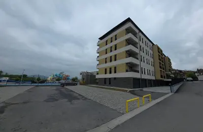 a building on the side of a parking lot at Apartmani Central A20 & Free parking in Vrnjci