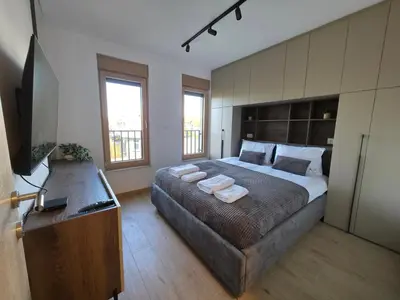 a bedroom with a large bed with towels on it at Apartmani Central A20 & Free parking in Vrnjci