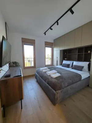 a large bedroom with a large bed and a desk at Apartmani Central A20 & Free parking in Vrnjci