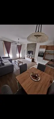 a living room with a table with a plate of food on it at Apartman Mila lux Vrnjačka Banja in Vrnjačka Banja