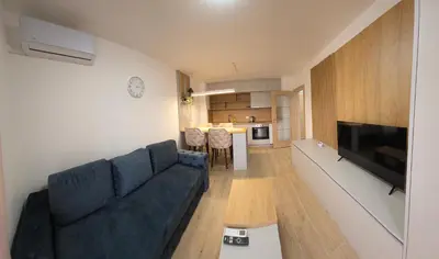 a living room with a blue couch and a kitchen at Apartmani Central A11 & Free parking in Vrnjci