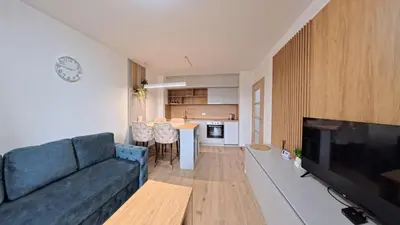 a living room with a blue couch and a kitchen at Apartmani Central A11 & Free parking in Vrnjci