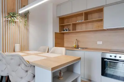 a kitchen with a wooden table and white cabinets at Apartmani Central A11 & Free parking in Vrnjci