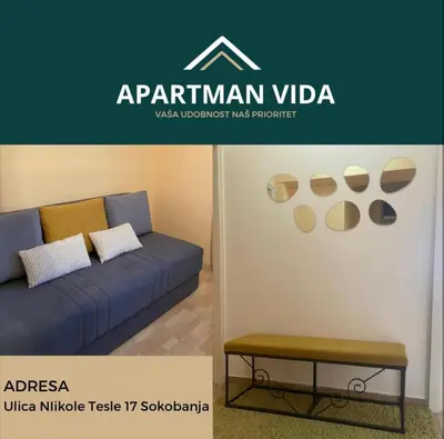 a blue couch and a bench in a room at Apartman Vida in Soko Banja