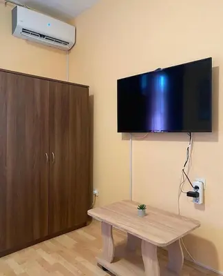a living room with a table and a flat screen tv at Apartman Vida in Soko Banja