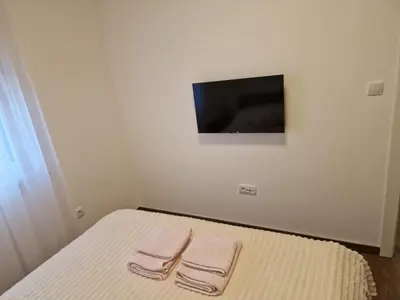 a bedroom with a bed with two towels on it at Apartman Miha Vrnjačka Banja in Vrnjci