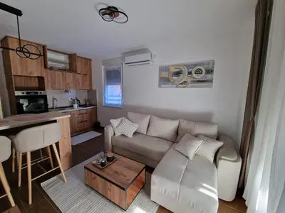 a living room with a couch and a kitchen at Apartman Miha Vrnjačka Banja in Vrnjci