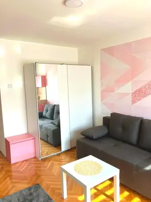 a living room with a couch and a mirror at Charming Downtown Room in Niš