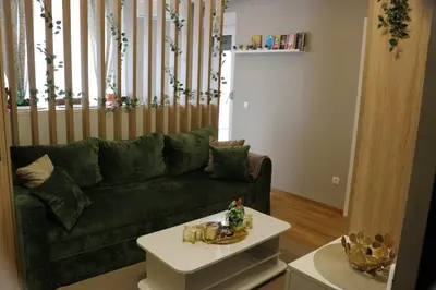 a living room with a green couch and a table at Mk Lux Apartman in Soko Banja