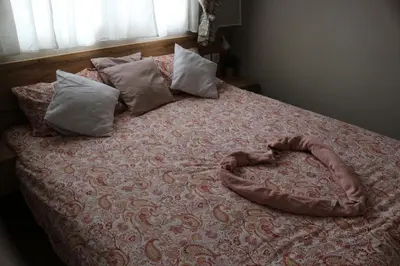 a bed with a heart shaped pillow on it at Mk Lux Apartman in Soko Banja