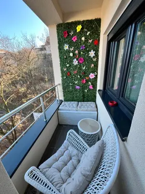 a balcony with two chairs and a flower wall at Mk Lux Apartman in Soko Banja