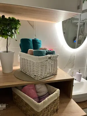 a basket of towels on a shelf in a bathroom at Mk Lux Apartman in Soko Banja