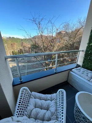 a balcony with two chairs and a table at Mk Lux Apartman in Soko Banja