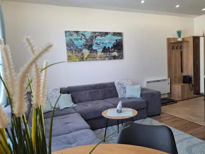 a living room with a blue couch and a table at Kopaonik-President kop APP Katarina- free wellness&spa in Kopaonik