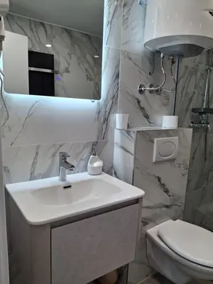 a bathroom with a sink and a toilet and a mirror at Kopaonik-President kop APP Katarina- free wellness&spa in Kopaonik