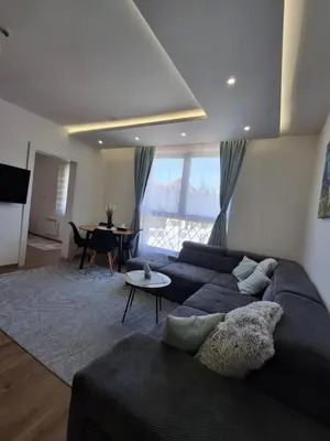 a living room with a blue couch and a table at Kopaonik-President kop APP Katarina- free wellness&spa in Kopaonik