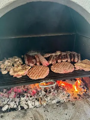 a group of meats and sausages on a grill at Vikendica Borjak in Kraljevo