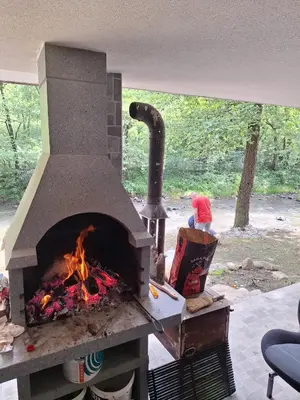 a brick oven with a fire inside of it at Vikendica Borjak in Kraljevo