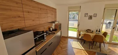 a kitchen with a table and a dining room at Apartman Vera in Vrnjačka Banja