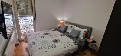 a bedroom with a bed with a blue and white comforter at Apartman Vera in Vrnjačka Banja