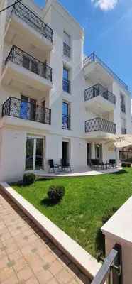 a large white building with benches in front of it at Apartman Vera in Vrnjačka Banja