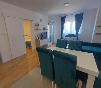 a living room with a table and a couch at Apartman TRI PRINCEZE in Soko Banja