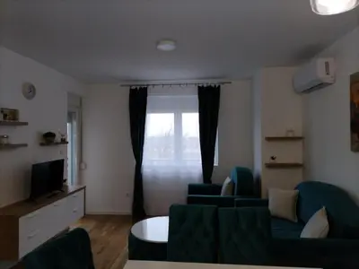 a living room with a couch and chairs and a window at Apartman TRI PRINCEZE in Soko Banja