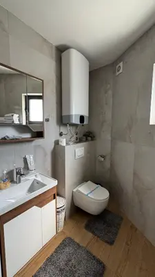 a bathroom with a sink and a toilet and a mirror at Apartman Sunce Lux A in Vrnjačka Banja