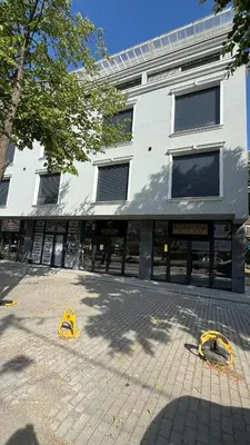 a building with windows and yellow objects in front of it at Apartman Sunce Lux A in Vrnjačka Banja