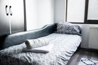 a bed with a blanket and pillows on it at Apartman Maja in Niš