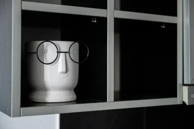 a vase with glasses sitting in a cabinet at Apartman Maja in Niš