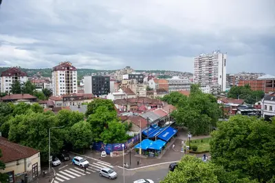 a city with cars parked in a parking lot at Apartman Maja in Niš