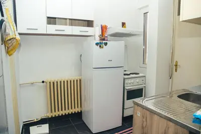a kitchen with a white refrigerator and a stove at Plan B in Niš