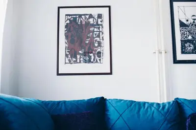 a blue couch in a living room with a picture on the wall at Plan B in Niš