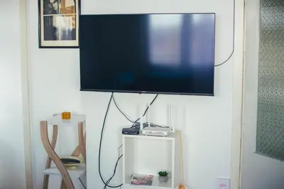 a flat screen tv hanging on a white wall at Plan B in Niš