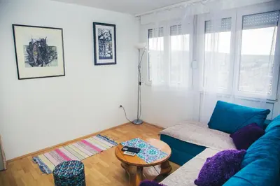 a living room with a blue couch and a table at Plan B in Niš