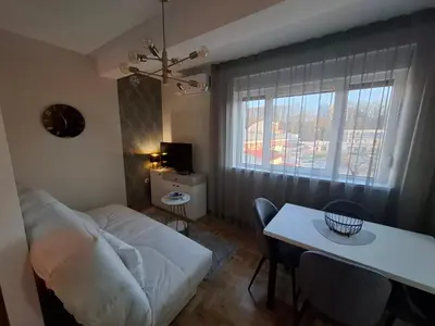 a living room with a white couch and a table at Astera 3 in Vrnjci
