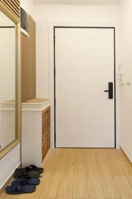 a white door in a room with shoes on the floor at Apartman Dolly Vrnjacka banja in Vrnjačka Banja