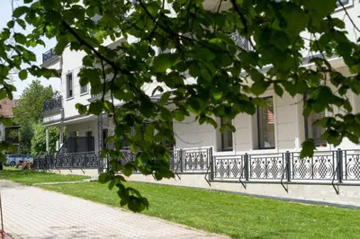 a white house with a fence in front of it at Apartman Dolly Vrnjacka banja in Vrnjačka Banja